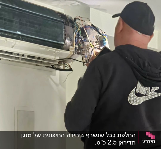 טכנאי בודק מזגן עם חוטים חשופים